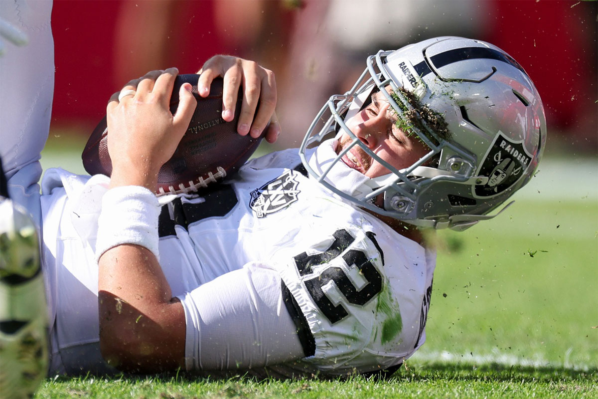 Las Vegas Raiders quarterback Aidan O'Connell (12) is sacked by Tampa Bay Buccaneers linebacker Lavonte David (54) in the first quarter at Raymond James Stadium.
