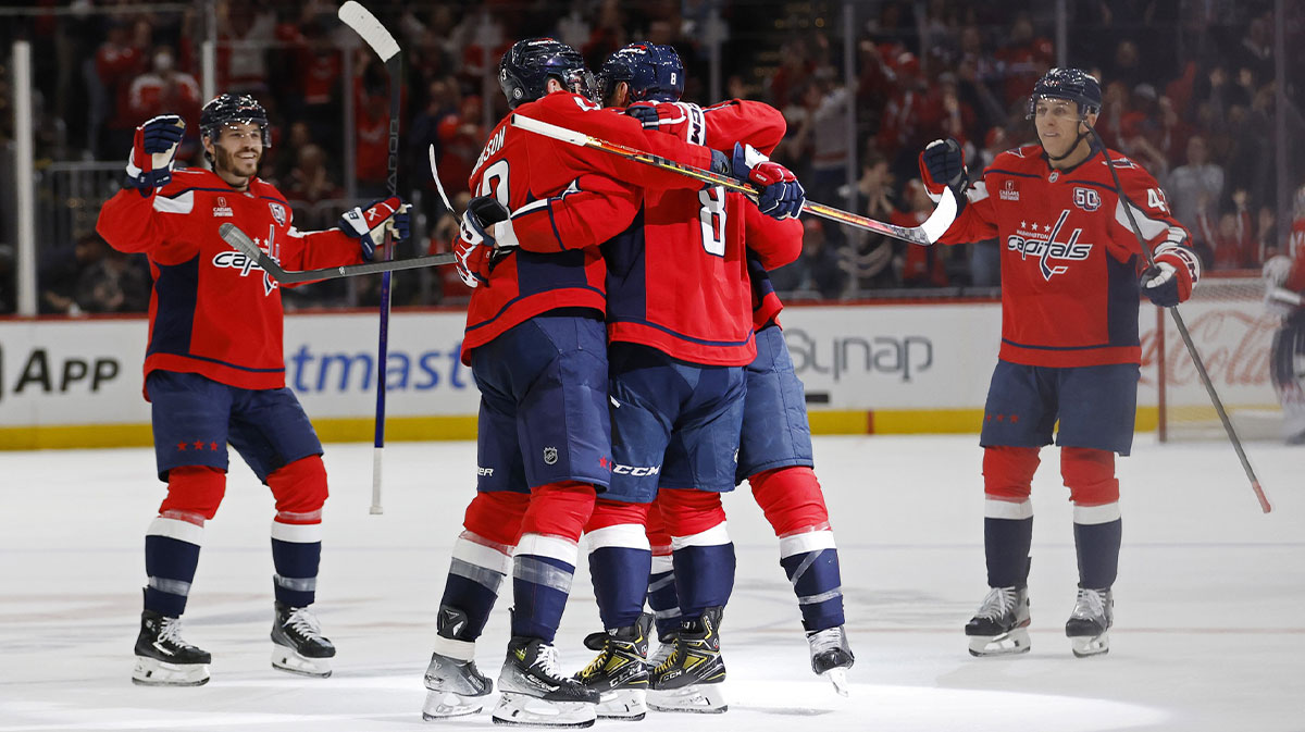 Washington Capitals left wing Alex Ovechkin (8) celebrates with teammates after scoring an empty net goal against the Seattle Kraken in the third period at Capital One Arena.