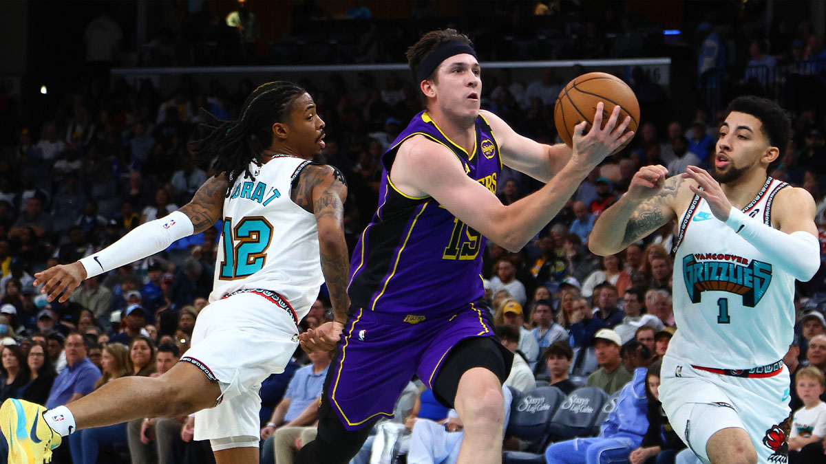 Los Angeles Lakers guard Austin Reaves (15) drives to the basket between Memphis Grizzlies guard Ja Morant (12) and Memphis Grizzlies guard Scotty Pippen Jr. (1) during the second quarter at FedExForum.